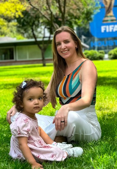 Maitte Weyr sentada na grama com a filha